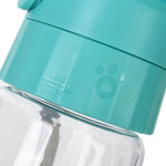 Dog drinking from portable travel water bottle outdoor park